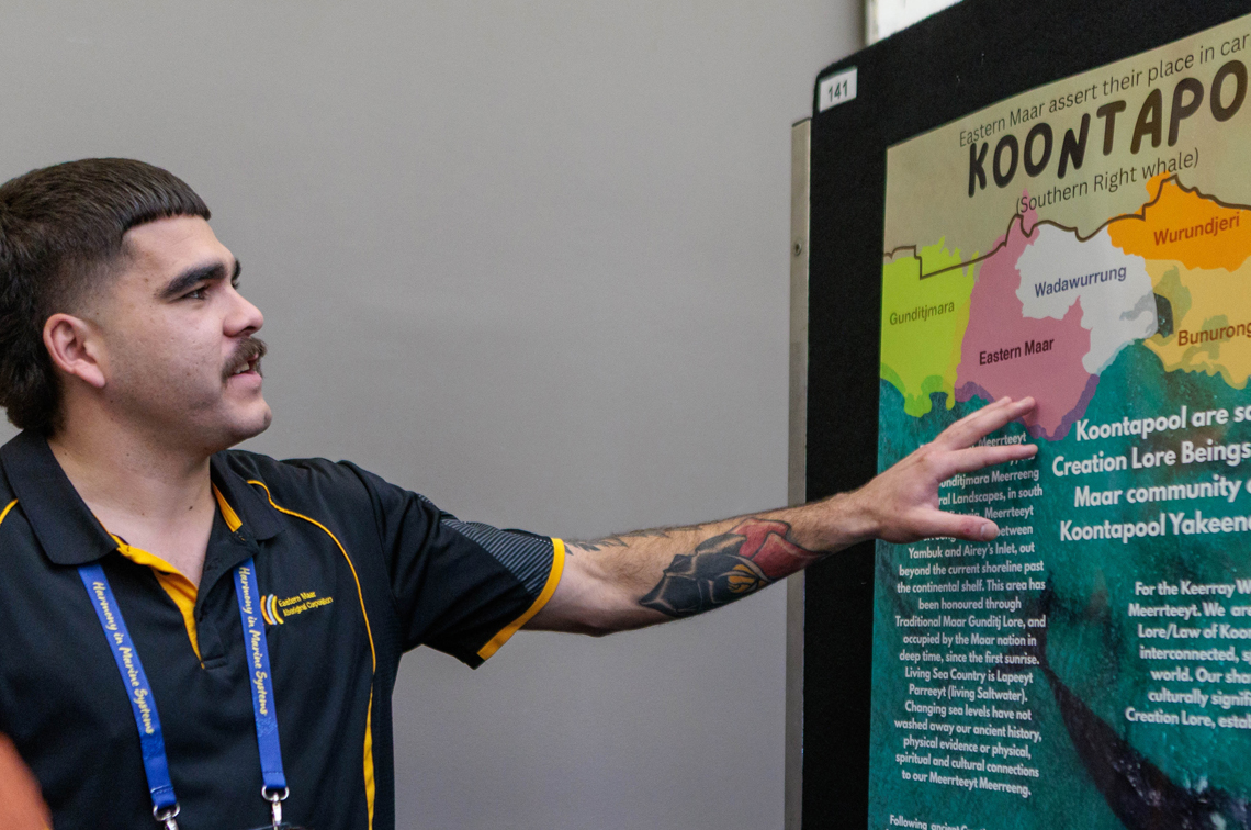 Phillip Chatfield of Eastern Maar Aboriginal Corporation, Warranmbool, Victoria, with the conference poster: ‘Eastern Maar assert their place in caring for Koontapool (southern right whale) and sea Country’. Image: Ascent Media 