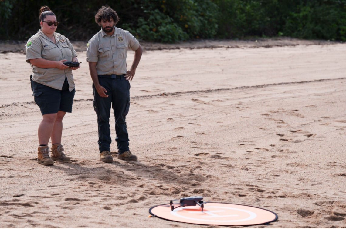 Girringun Rangers Shantaishe Congoo (left) and Doug Bulmer (right) preparing for drone take-off to conduct intertidal seagrass surveys on Girramay Country at Meunga Creek, QLD. Image: Styledia.